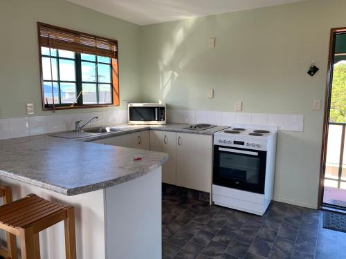 a kitchen with a white stove and a sink at 3 Bedroom Apartment, Kaikoura in Kaikoura