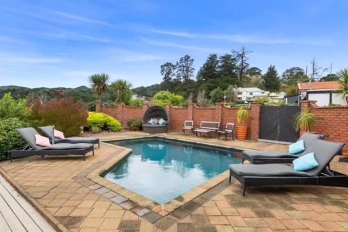 a swimming pool with couches and chairs in a backyard at Chartré Manor B&B in Thames