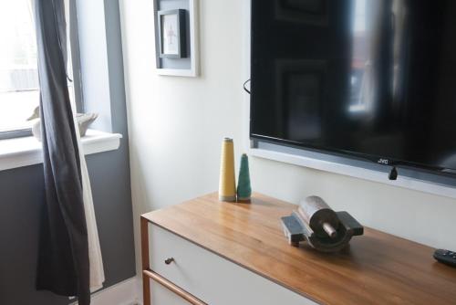 a flat screen tv sitting on top of a dresser at Henry Norman Hotel in Brooklyn