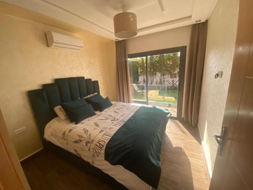 um quarto com uma cama grande e uma janela grande em VILLA AMALOU AVEC PISCINE FAMILLE UNIQUEMENt em Agadir