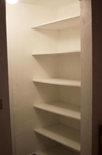 a closet with white shelves in a room at Super Precio in Guatemala