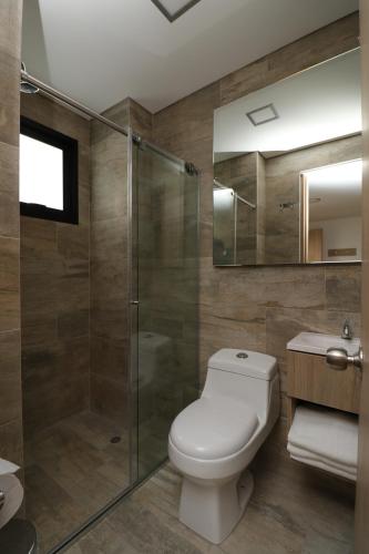 a bathroom with a toilet and a glass shower at Normandía Tower in Bogotá