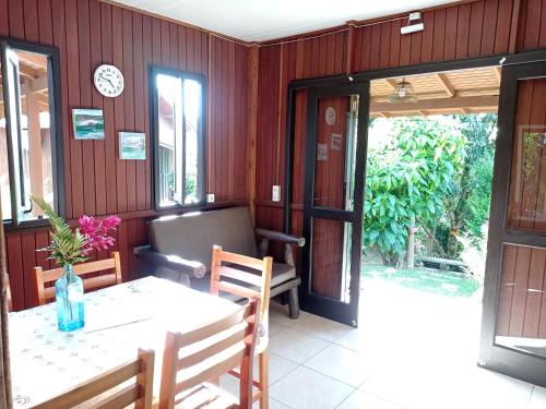 Pousada Biso Finoca Ibiraquera في إيمبيتوبا: غرفة طعام مع طاولة وكراسي ونافذة