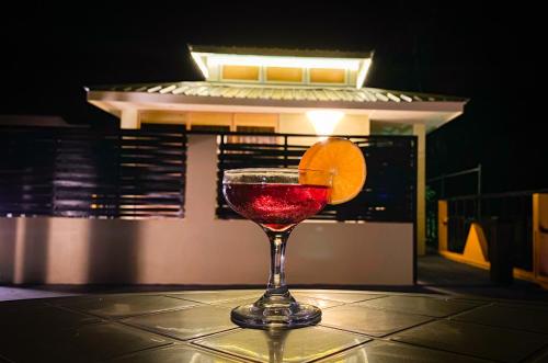 a drink in a glass with an orange on a table at Manta Dhangethi in Dhangethi