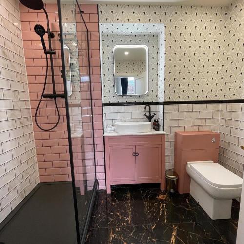a pink bathroom with a sink and a toilet at Atholl Arms Hotel Dunkeld in Dunkeld