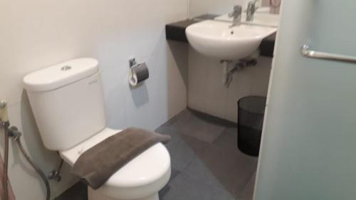 een badkamer met een wit toilet en een wastafel bij Liberta Hub Singosari Malang in Malang