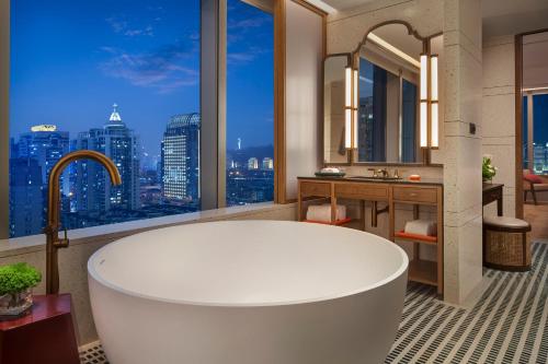 a bathroom with a tub and a view of the city at Andaz Xiamen in Xiamen