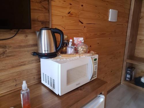 um micro-ondas com uma cafeteira em cima em Cabana Frio da Serra em Urubici