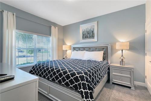 Schlafzimmer mit einem Bett mit einer schwarzen und weißen Bettdecke in der Unterkunft Storey Lake 4 Bedroom Townhome townhouse in Kissimmee