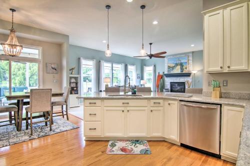 a kitchen with white cabinets and a dining room at 5 Mi to Bethany Beach Chic Home with Grill! in Ocean View