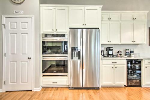 a kitchen with white cabinets and a stainless steel refrigerator at 5 Mi to Bethany Beach Chic Home with Grill! in Ocean View