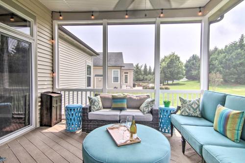 a screened porch with blue furniture and a large window at 5 Mi to Bethany Beach Chic Home with Grill! in Ocean View
