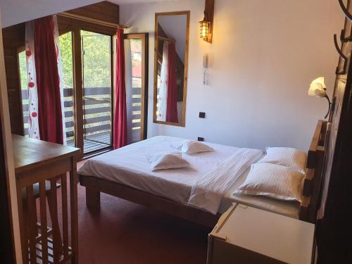 Schlafzimmer mit einem Bett, einem Tisch und einem Fenster in der Unterkunft Pensiunea Melinda in Petroşani