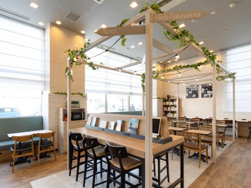 a restaurant with wooden tables and chairs and lights at Comfort Hotel Toyama in Toyama
