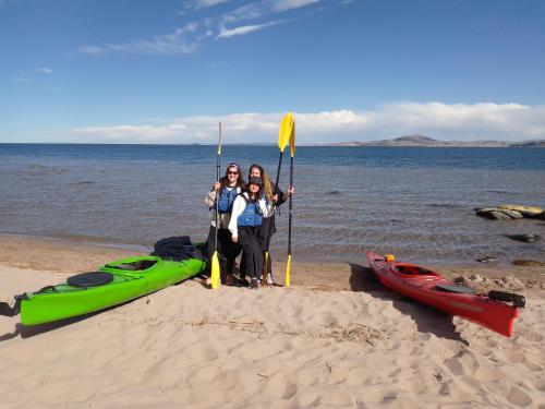 a group of people standing on the beach with their kayaks at "Casa de Valentin" in Llachon