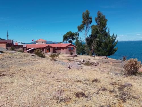 a house on a hill next to the ocean at "Casa de Valentin" in Llachon