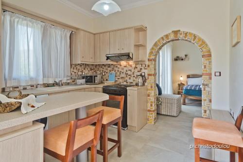 a kitchen with an archway and a room with a bed at Olive Studios Karpathos Studio #4 in Karpathos