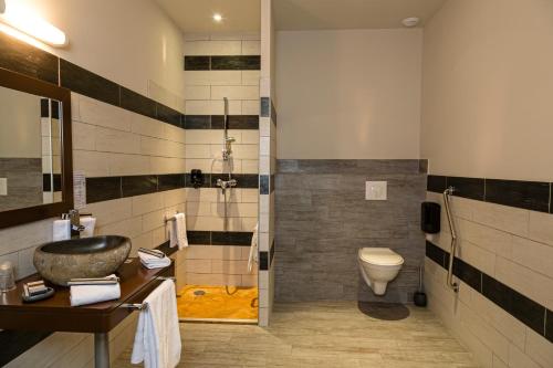a bathroom with a sink and a shower and a toilet at Le Ya'Tis in Saint-Laurent-des-Arbres