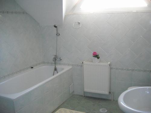 een badkamer met een bad en een wastafel bij Pension La Noblesse in Boekarest
