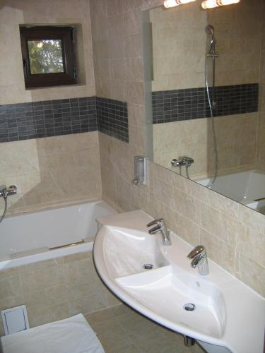a bathroom with a sink and a tub and a mirror at Timis Valley, Casa Eni&Dan in Predeal