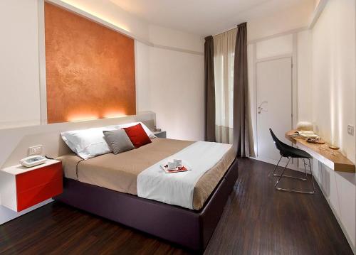 a bedroom with a bed and a desk with a chair at Acapulco Hotel in Cattolica