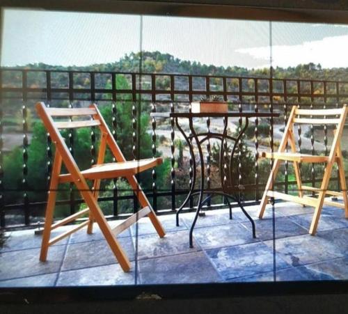 two chairs and a table on a balcony at Cal Baster in Vallbona de les Monges
