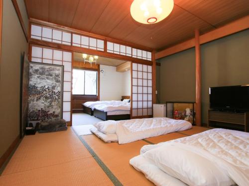 1 dormitorio con 2 camas y TV. en Kinoie - Vacation STAY 19748v, en Toyooka