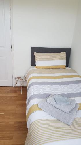 a bed with towels on it in a room at Bader House in Aberporth