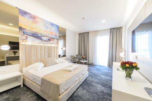 a bedroom with a bed and a large painting on the wall at Mirage Beach Spa Hotel in Eforie Nord