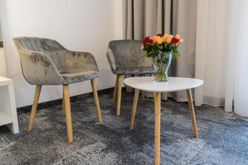 two chairs and a vase of flowers on a table at Mirage Beach Spa Hotel in Eforie Nord