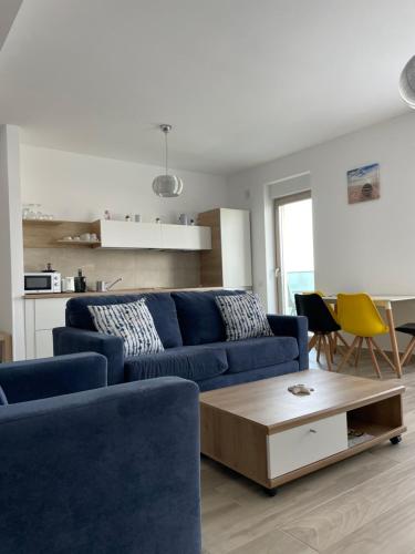 sala de estar con sofá azul y mesa en Vela Luxury Sea View Apartments - Marina Surf, en Mamaia Nord – Năvodari
