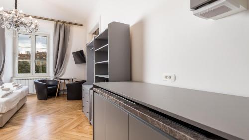 een keuken met aanrechtblad en een woonkamer bij Apartments ART TEATRO in Rijeka