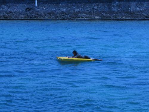 a person laying on a surfboard in the water at Grand Luley Manado in Manado