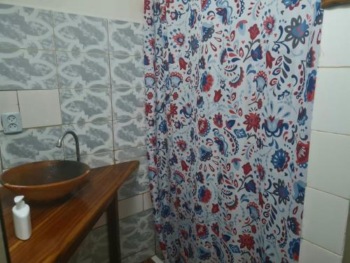 a bathroom with a sink and a shower curtain at Casa Brisa in Inhambane