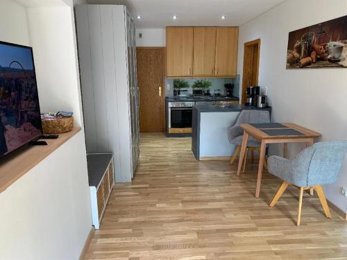 a kitchen with a table and chairs and a table and a kitchen at Appartement Sonnenblick in Kollnburg