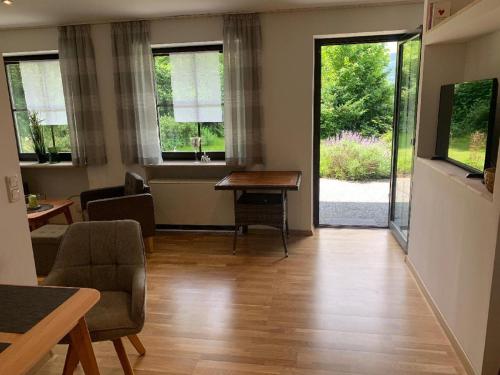 a living room with a table and chairs and windows at Appartement Sonnenblick in Kollnburg