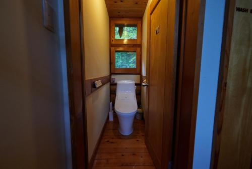 a small bathroom with a toilet in a house at SUNNSNOW Loghouse in Otari