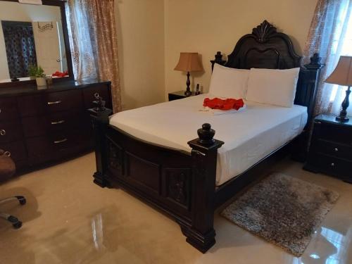 a bedroom with a large bed and a dresser at Sweet Holiday Haven in Ocho Rios