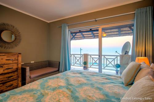 a bedroom with a bed and a view of the ocean at 8 Waterfront in Umdloti