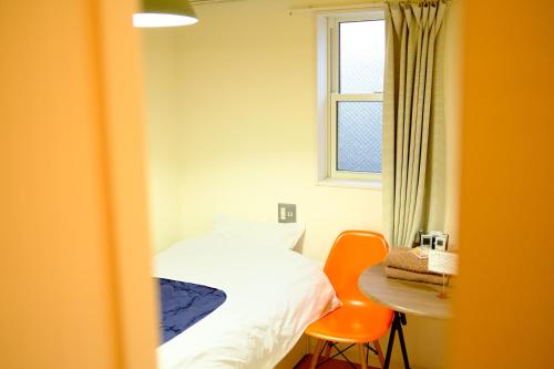 a bedroom with a bed and a table and a window at コージーイン 東京桜新町 in Tokyo