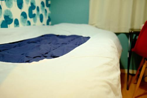 a close up of a white bed in a room at コージーイン 東京桜新町 in Tokyo