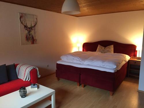 a bedroom with a bed and a red couch at Neu Renoviertes Ferienhaus Ahornli im Mölltal in Großkirchheim