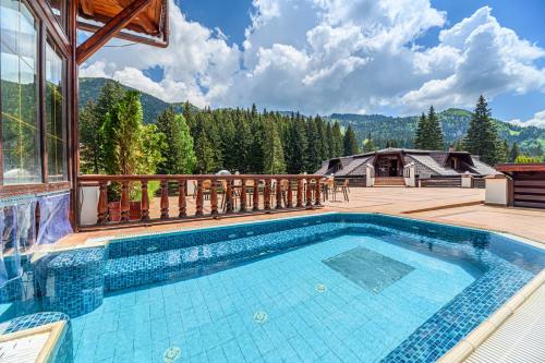 a pool on a deck with a view of the mountains at Aurelius Imparatul Romanilor Hotel & SPA in Poiana Brasov