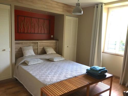 1 dormitorio con cama, mesa y ventana en LADOREPONTAISE, en Pondaurat