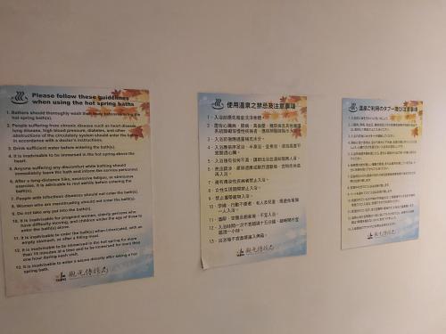 a menu on a wall with three signs on it at Beautyage Spring Hotel in Taipei