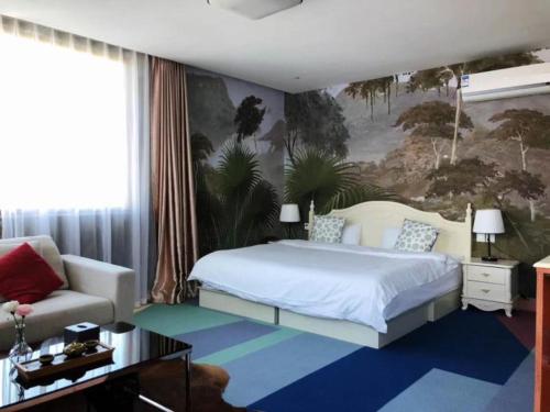 Xindao Xitai Xiaozhu Hotel في Huangkan: غرفة نوم بسرير كبير وأريكة