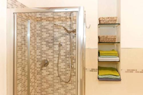 een badkamer met een douche en een glazen deur bij Casa Amorino in Lucca