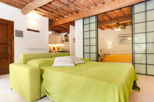 een slaapkamer met een groot groen bed in een kamer bij Casa Amorino in Lucca