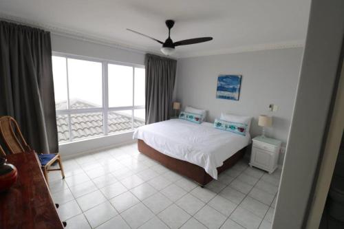 a bedroom with a bed and a large window at Sorgente 304 with Inverter in Umdloti