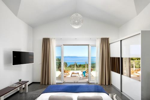 a bedroom with a bed and a view of the ocean at Luxury Panorama Vila with amazing Seaview in Gondolici 7 km from Rabac in Labin